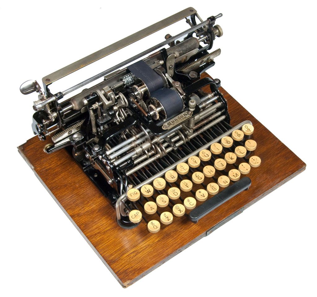 Oblique view of the Munson 1 typewriter on a square wooden base, small file. (sold)